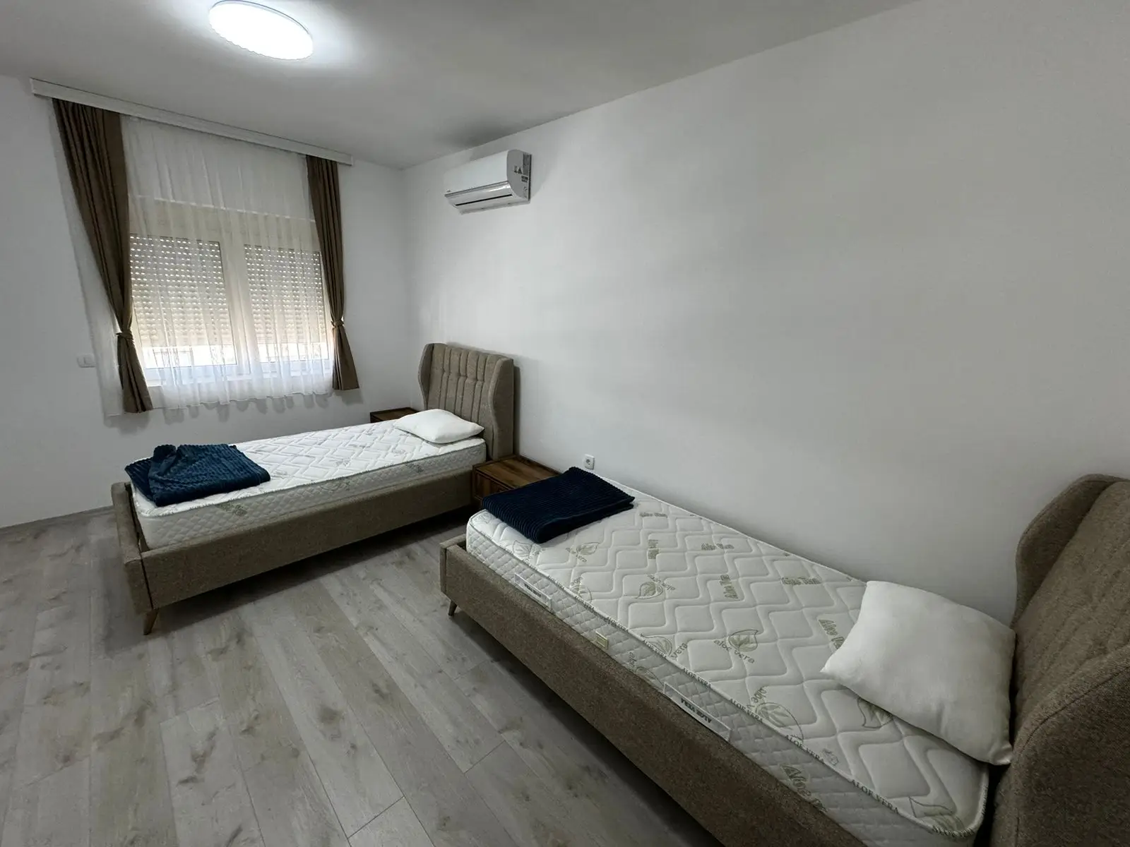 Modern Ulcinj bedroom with twin beds, wood floors, AC&mdash;ideal Montenegro real estate. Listed on montenegro-listings.me by Ekosphere DOO.
