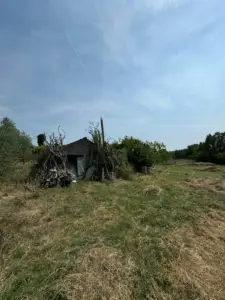 Ulcinj investment opportunity: rustic shed on grassy field, surrounded by nature—exclusive on montenegro-listings.me by ekosphere doo.