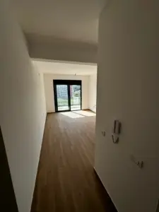 Modern empty room with white walls, wood floors, balcony and panoramic Ulcinj views—exclusive listing on montenegro-listings.me by ekosphere doo.