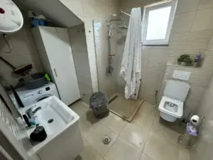 Modern bathroom in Ulcinj property with beige tiles, glass shower, premium fixtures—exclusive listing on montenegro-listings.me by Ekosphere.