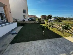 Modern white property with manicured lawn and tiled patio in Ulcinj, top real estate from montenegro-listings.me by ekosphere doo.