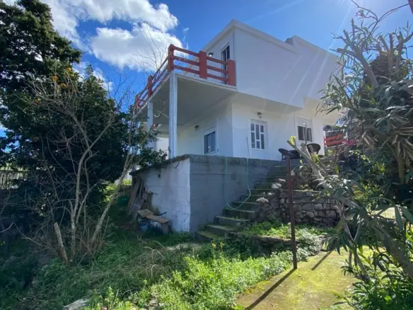 Stunning two-story white house with red balcony, sunlit yard on a grassy slope&mdash;prime Ulcinj real estate via montenegro-listings.me by ekosphere doo.