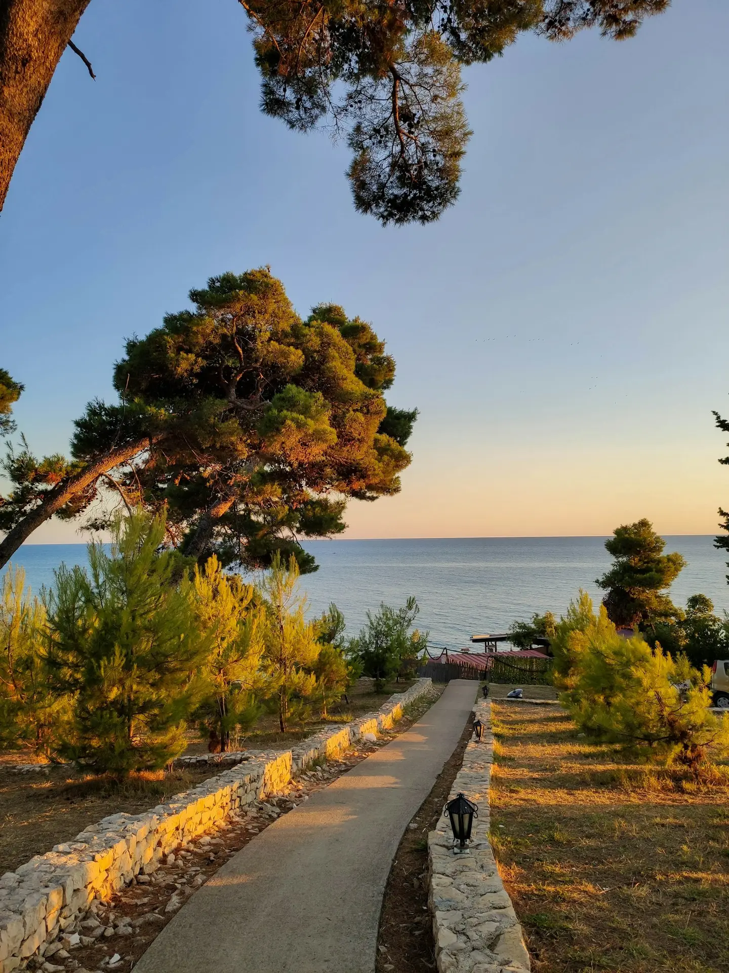 Plots of land in Ulcinj 1 Sunset illuminates a scenic path to the Adriatic, showcasing prime Ulcinj real estate by montenegro-listings.me—by Ekosphere DOO.