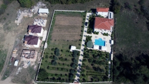 Stunning aerial view of gated Ulcinj property: two red-roof homes, pool, gardens—prime real estate by ekosphere doo, invest now!.