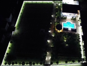 Stunning aerial night view of an illuminated Ulcinj property with pool, gardens—prime investment via Montenegro-Listings.me by Ekosphere.