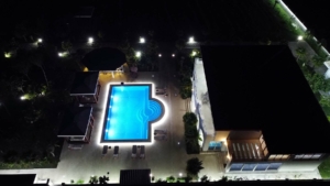 Luxurious illuminated pool with cabanas and lounge area at premium Ulcinj property—exclusive on montenegro-listings.me by Ekosphere doo.