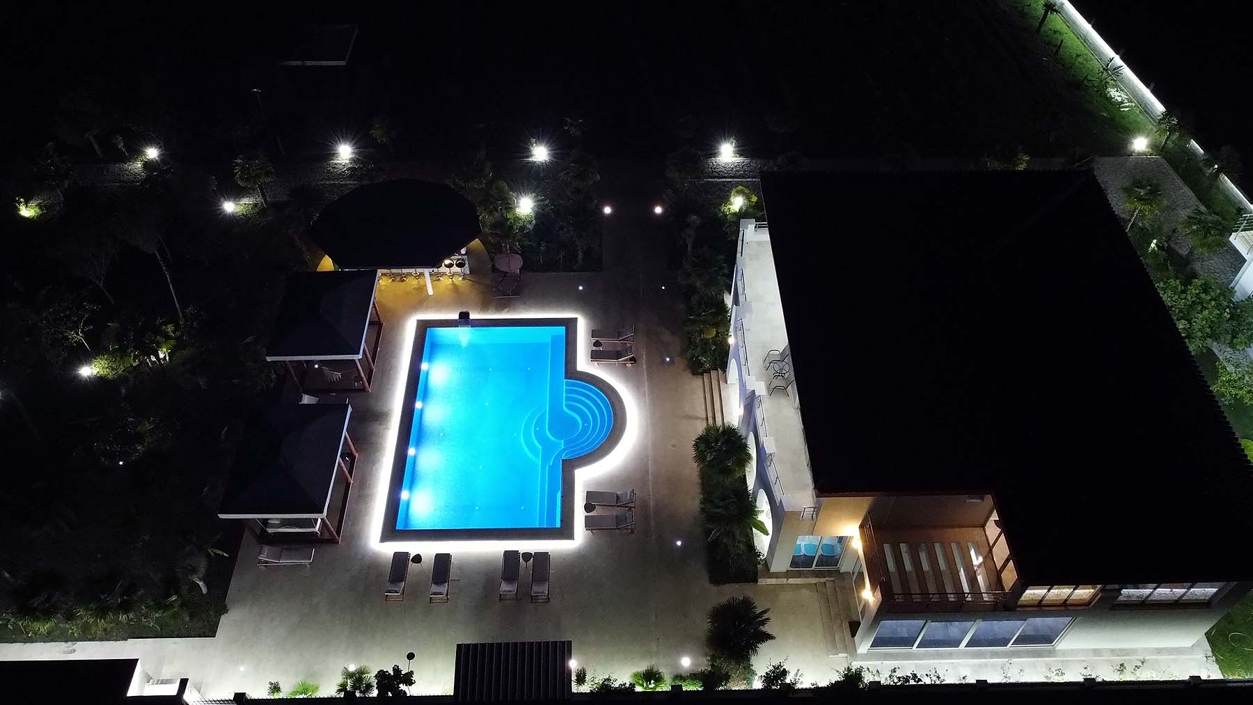 Luxurious illuminated pool with cabanas and lounge area at premium Ulcinj property&mdash;exclusive on montenegro-listings.me by Ekosphere doo.