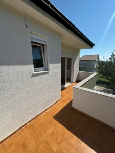 Bright balcony in Ulcinj, Montenegro with tiled floors, glass doors, and scenic views—top real estate by Ekosphere on montenegro-listings.me.