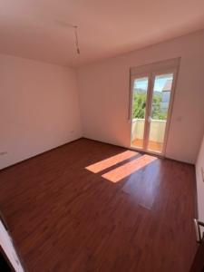 Bright Ulcinj apartment with sunlit wood floors, balcony with greenery; top Montenegro real estate investment by ekosphere doo.