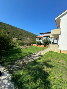 Modern white villa with balconies, lush yard, and mountain views in Ulcinj—prime Montenegro real estate from Ekosphere at montenegro-listings.me.