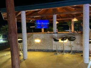 Stunning outdoor bar with tiled counter and TV, under elegant beams—exclusive Ulcinj real estate at montenegro-listings.me by Ekosphere.