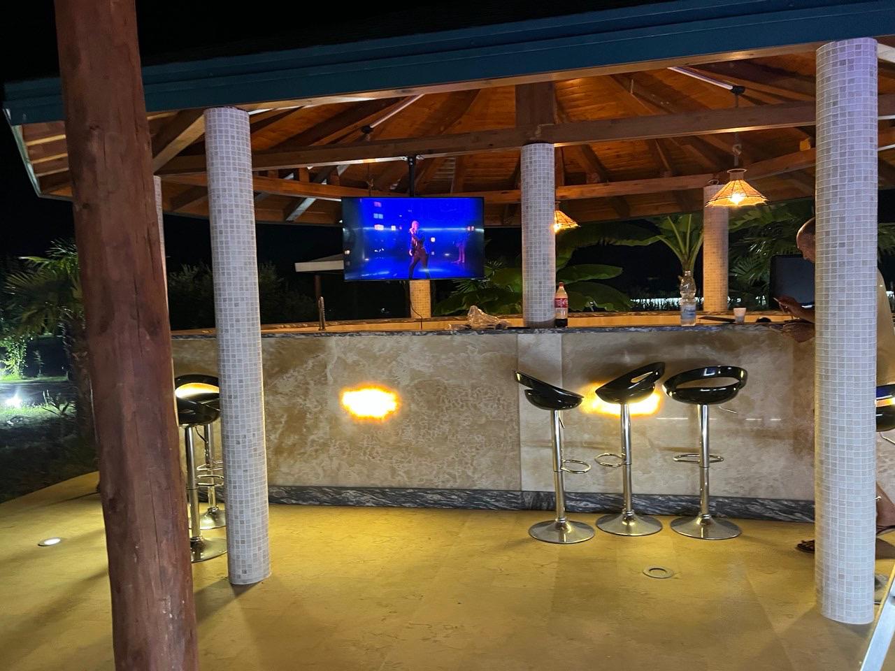 Stunning outdoor bar with tiled counter and TV, under elegant beams&mdash;exclusive Ulcinj real estate at montenegro-listings.me by Ekosphere.