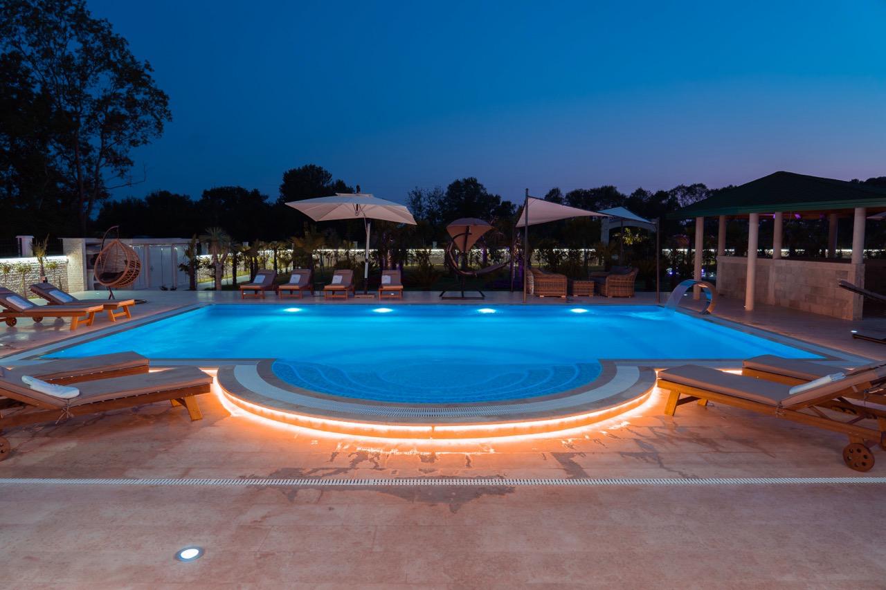 Luxury Ulcinj property: night-lit pool, elegant loungers, lush trees&mdash;prime investment on Montenegro-Listings.me by Ekosphere doo.