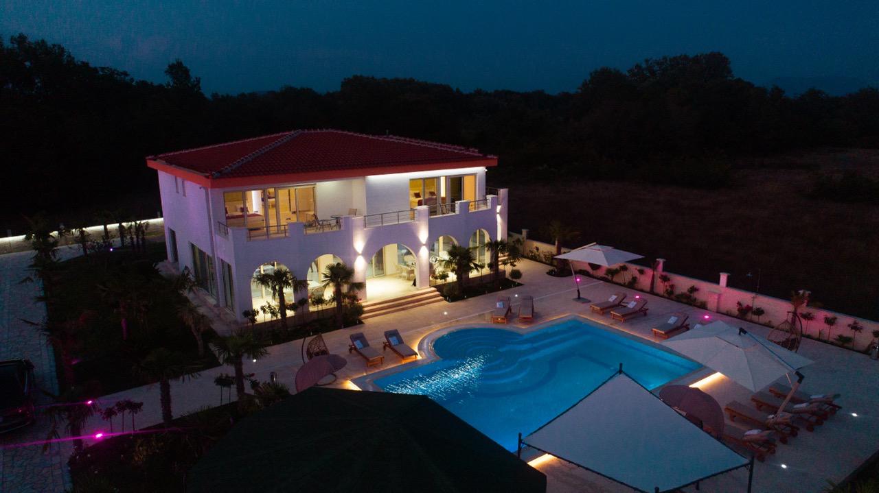 Stunning two-story white villa with red roof, balconies, pool, and lush ekosphere gardens&mdash;prime Ulcinj real estate by montenegro-listings.me.