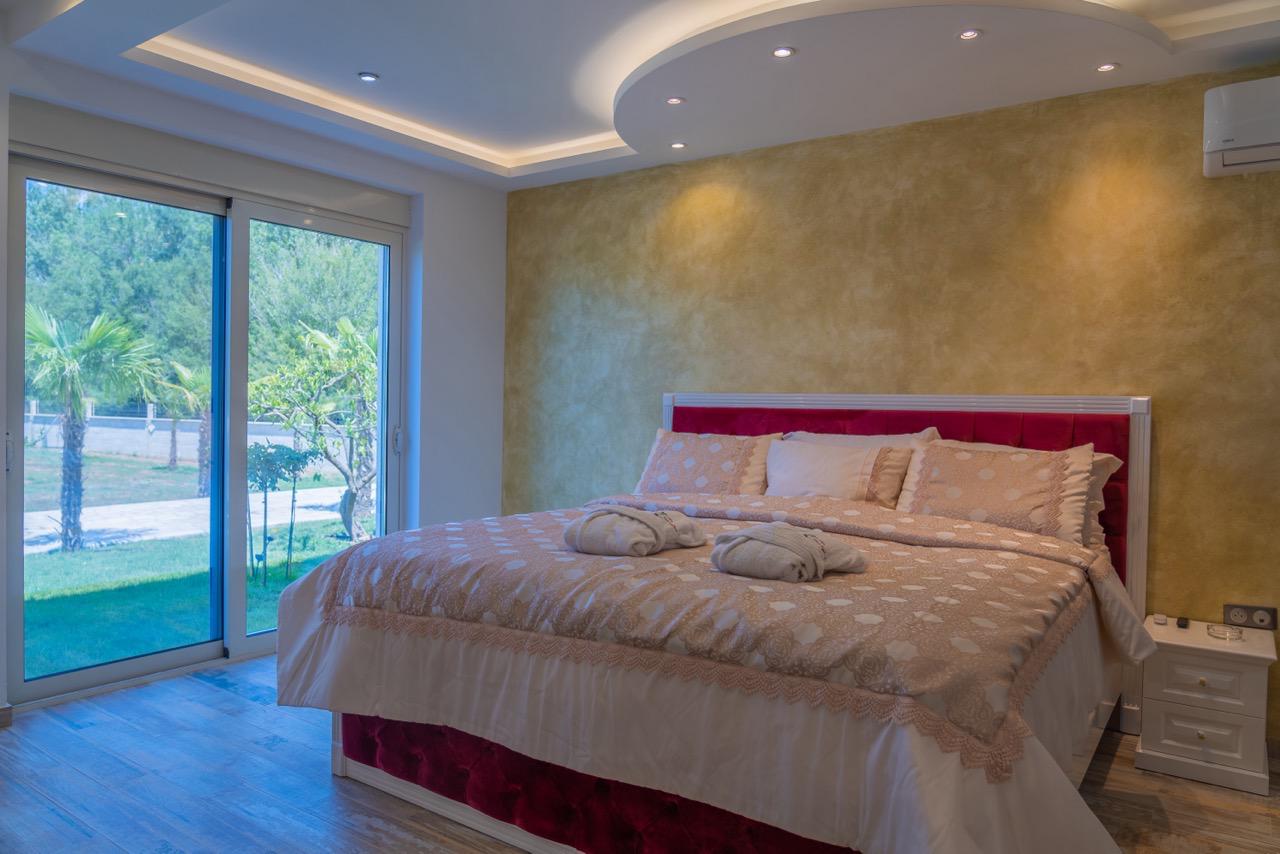 Modern Ulcinj bedroom by Ekosphere: gold accent wall, glass doors, designer lighting. Invest via montenegro-listings.me today.