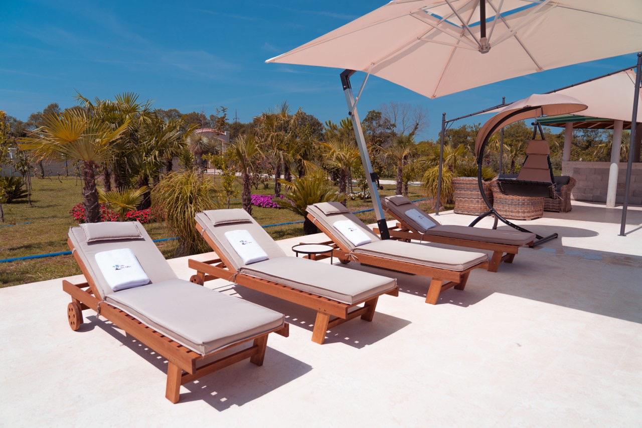 Luxury real estate in Ulcinj, Montenegro: poolside lounge, palm trees, modern amenities&mdash;a prime investment at Ekosphere by montenegro-listings.me.