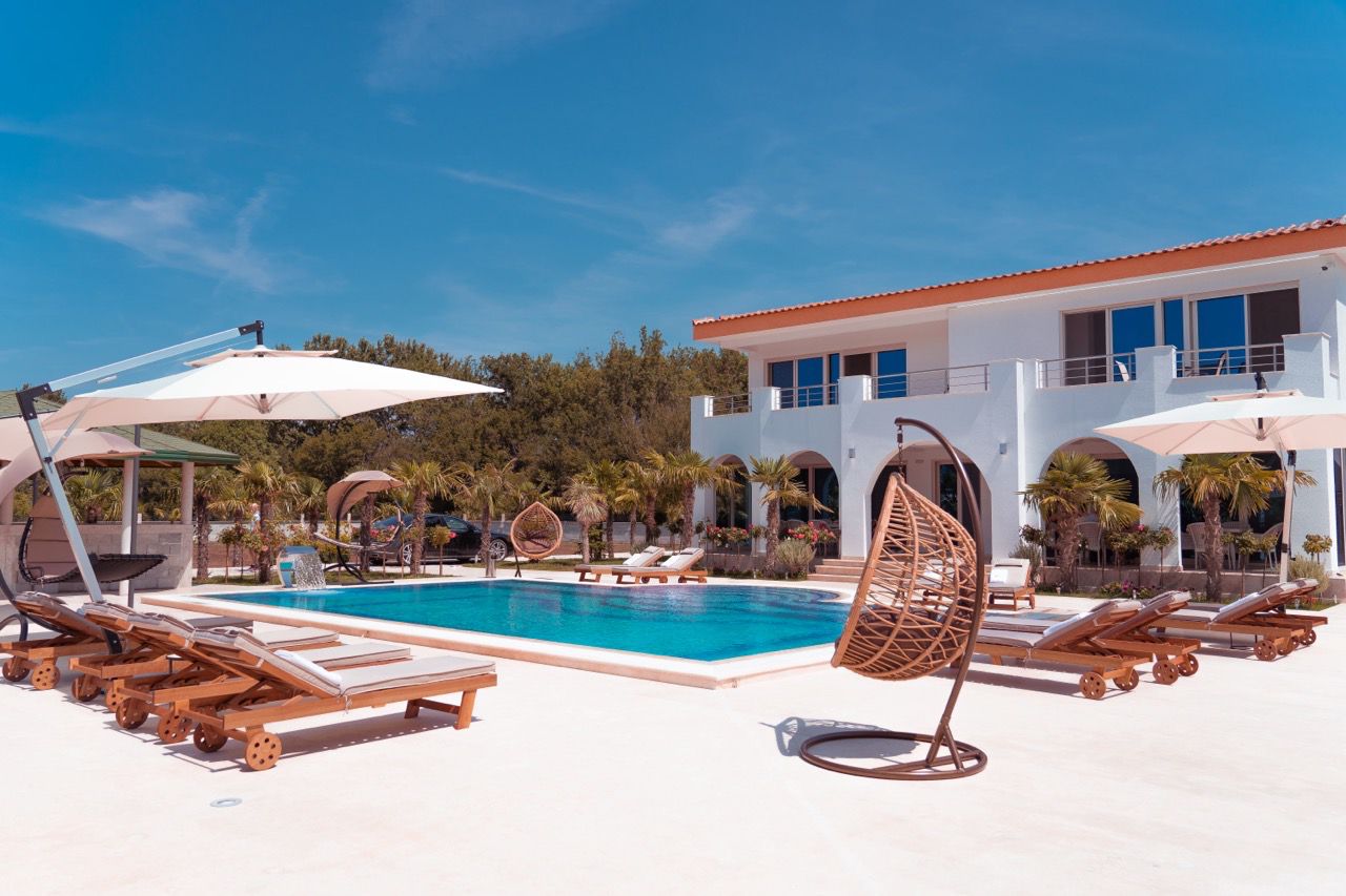 Luxurious modern villa with pool, lush palms, and spacious balconies in Ulcinj&mdash;exclusive Ekosphere DOO listing on montenegro-listings.me.