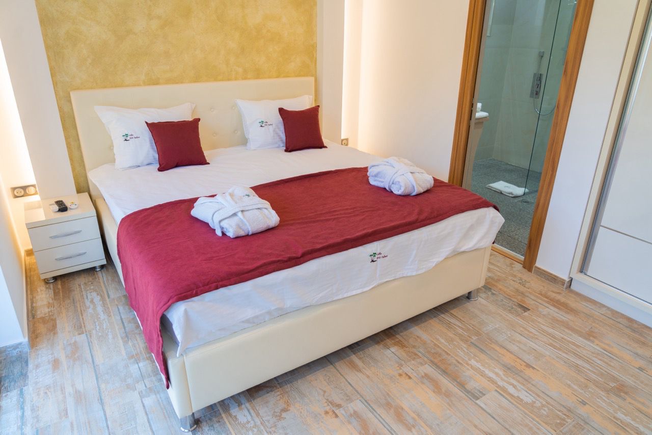 Modern Ulcinj bedroom with stylish red bedding, white headboard, ensuite bath&mdash;ideal investment via montenegro-listings.me by ekosphere doo.