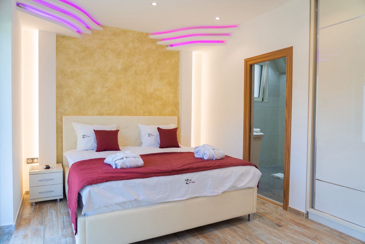 Stylish Ulcinj hotel room with luxury bed, chic lighting, gold accent wall, and ensuite&mdash;ideal for property investors via montenegro-listings.me by ekosphere doo.