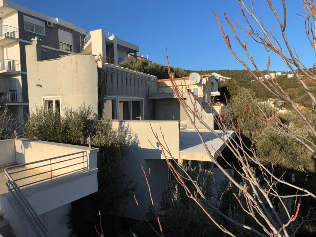 Luxury multi-story grey and white building with balconies in Ulcinj, Montenegro—prime real estate by montenegro-listings.me.