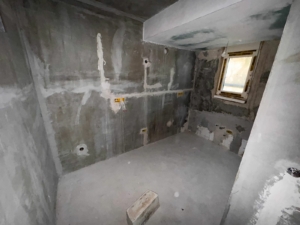 Spacious unfinished concrete room with utility points, large window, and investment potential in Ulcinj—exclusive at montenegro-listings.me by Ekosphere doo.