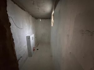 Unfinished Ulcinj investment property with concrete interiors, high window, exposed pipes—exclusive on montenegro-listings.me by Ekosphere DOO.
