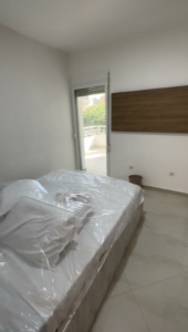 Modern Ulcinj bedroom with balcony access, double bed, tiled floor—prime Montenegro real estate by montenegro-listings.me/Ekosphere.