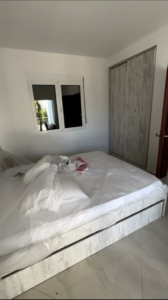 Spacious Ulcinj bedroom with tiled floors, large white bed, ample wardrobe, bright window—ideal Montenegro investment by ekosphere doo.