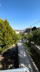 Scenic tiled path curves through lush greenery toward prime Ulcinj properties—exclusive on montenegro-listings.me by ekosphere doo.