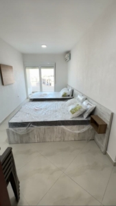 Bright Ulcinj bedroom with twin beds, balcony access, and modern furnishings—prime investment on montenegro-listings.me by ekosphere doo.