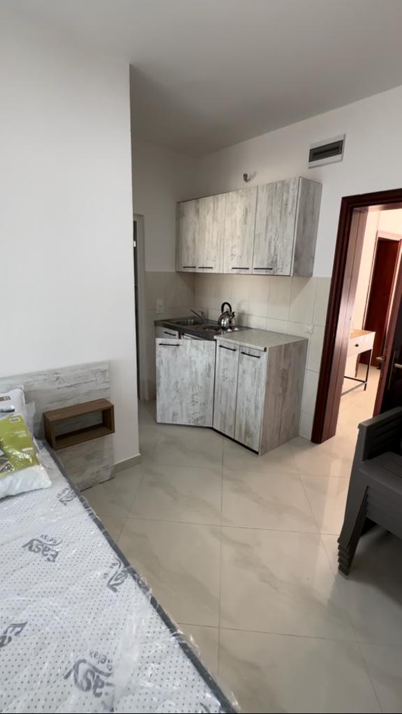 Modern kitchenette with light wood cabinets, tiled backsplash, and cozy sleeping area&mdash;ideal Ulcinj investment at montenegro-listings.me by ekosphere doo.
