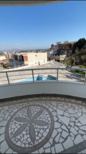 Modern balcony with flower mosaic tile flooring, street and building views in Ulcinj—prime real estate from ekosphere’s montenegro-listings.me.