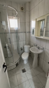 Modern bathroom with white tiles, glass shower, sleek fixtures—perfect Ulcinj investment. Exclusive at montenegro-listings.me by ekosphere doo.