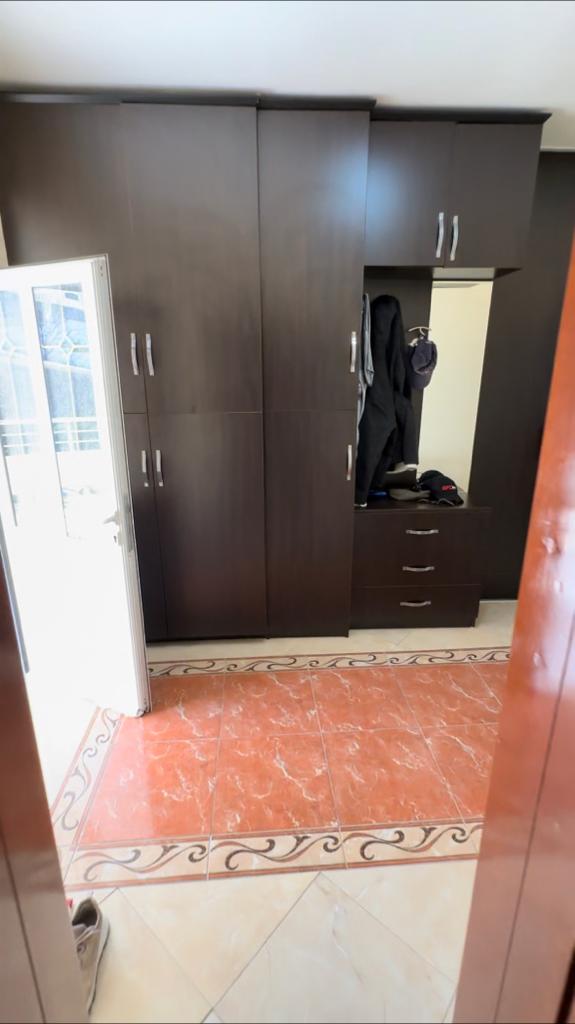 Spacious dark brown wardrobe with versatile storage, modern tiles, and bright open-door lighting&mdash;ideal for Ulcinj investments. Montenegro-listings.me by ekosphere doo.