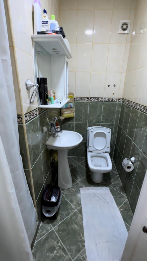 Modern Ulcinj property bathroom with elegant green and beige tiles, full amenities; exclusive at montenegro-listings.me by ekosphere doo.