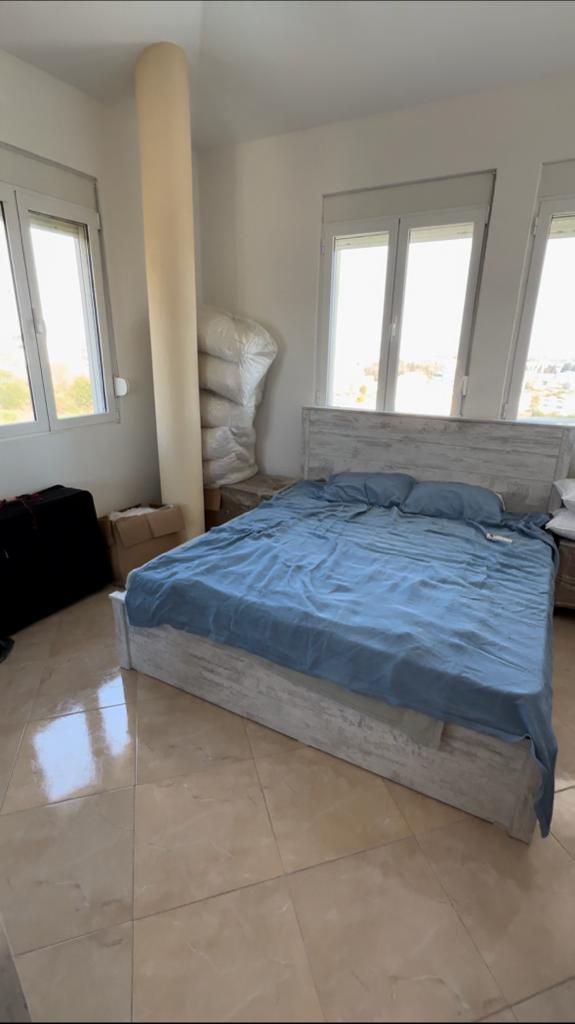 Invest in Ulcinj: spacious bedroom with double bed, blue linens, tiled floors, 3 large windows&mdash;exclusive on montenegro-listings.me by ekosphere doo.