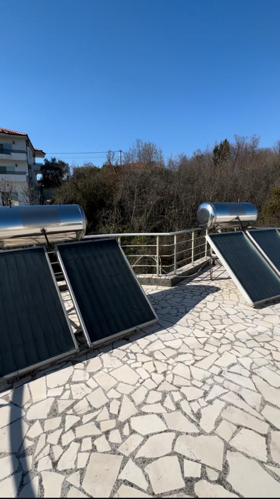 Modern solar water heaters on a tiled Ulcinj patio offer eco-investment appeal&mdash;exclusive at montenegro-listings.me, by ekosphere doo.