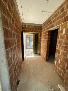 Bright, unfinished red brick space with dual open doorways—prime Ulcinj investment listed by montenegro-listings.me (ekosphere doo).