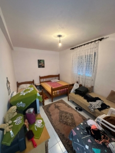 Charming Ulcinj bedroom with 2 single beds, window, rug & storage. Ideal Montenegro real estate. Eksophere doo—montenegro-listings.me.