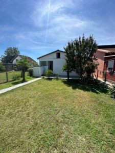 Charming white house with glass door on lush lawn, prime Ulcinj location near amenities—exclusive at montenegro-listings.me by ekosphere doo.