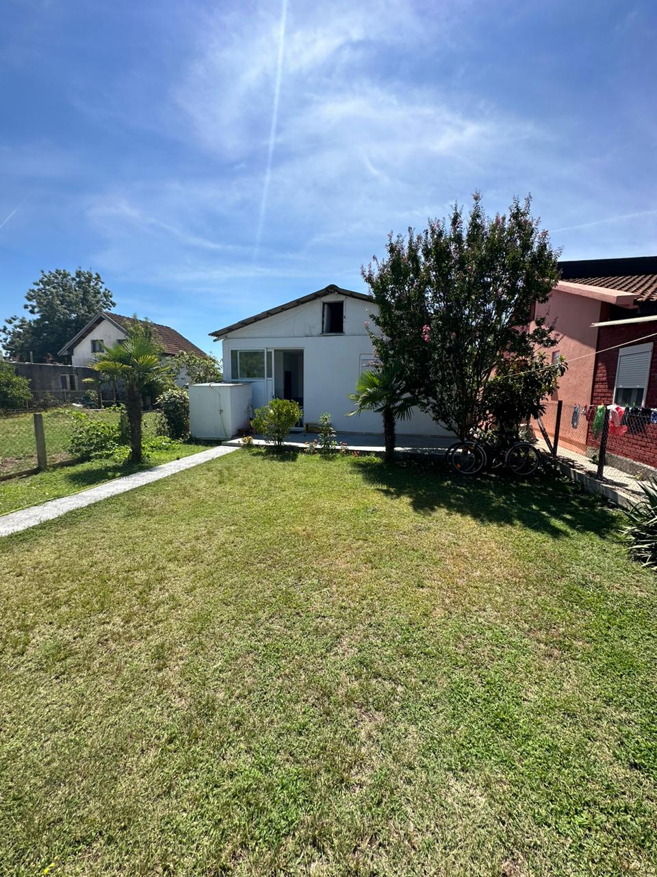 Charming white house with glass door on lush lawn, prime Ulcinj location near amenities&mdash;exclusive at montenegro-listings.me by ekosphere doo.