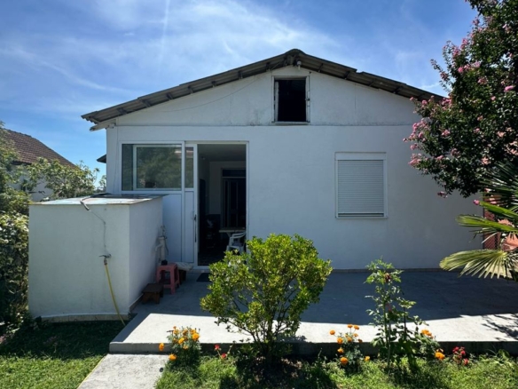 Charming white house in Ulcinj, Montenegro with patio, garden, and lawn—ideal for investment. Listed by ekosphere doo on montenegro-listings.me.