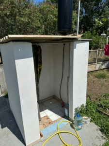 Modern outdoor shower with white walls, tiled floor, eco water tank—ideal Ulcinj property investment. By ekosphere doo on montenegro-listings.me.