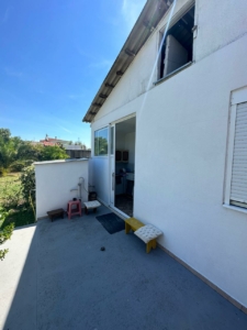 Sunny patio in Ulcinj, Montenegro with stylish seating, sliding glass door, and ekosphere-inspired interior—exclusive on montenegro-listings.me.