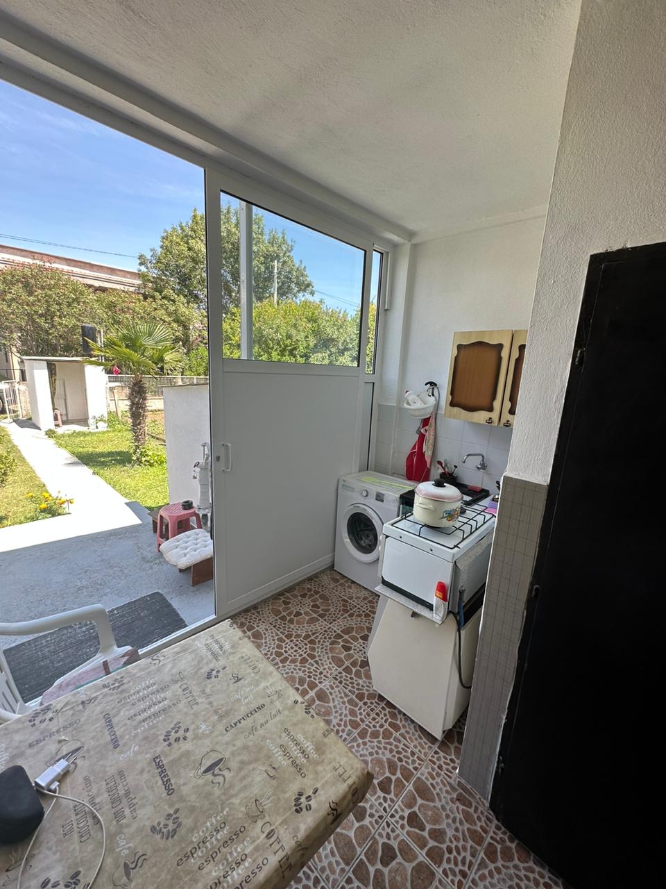 Modern Ulcinj laundry area with washer, stove, tiled floors, glass garden door&mdash;ideal eco-investment at montenegro-listings.me by Ekosphere.