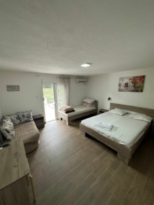 Bright, furnished Ulcinj bedroom with beds, sofa, desk & scenic views—prime investment via montenegro-listings.me by Ekosphere Doo.