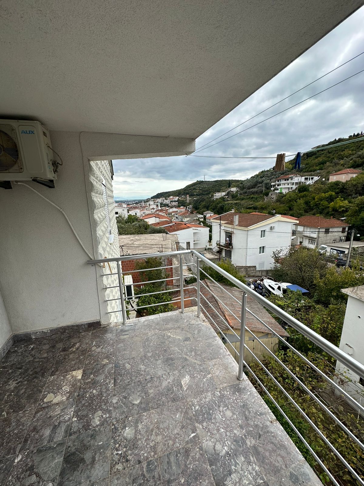Modern marble-floored balcony with scenic Ulcinj views&mdash;red-tile roofs, lush hills. Exclusive at montenegro-listings.me by Ekosphere Doo.