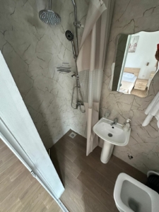 Modern bathroom in Ekosphere’s Ulcinj property: rainfall shower, elegant sink, quality fixtures—ideal real estate investment.