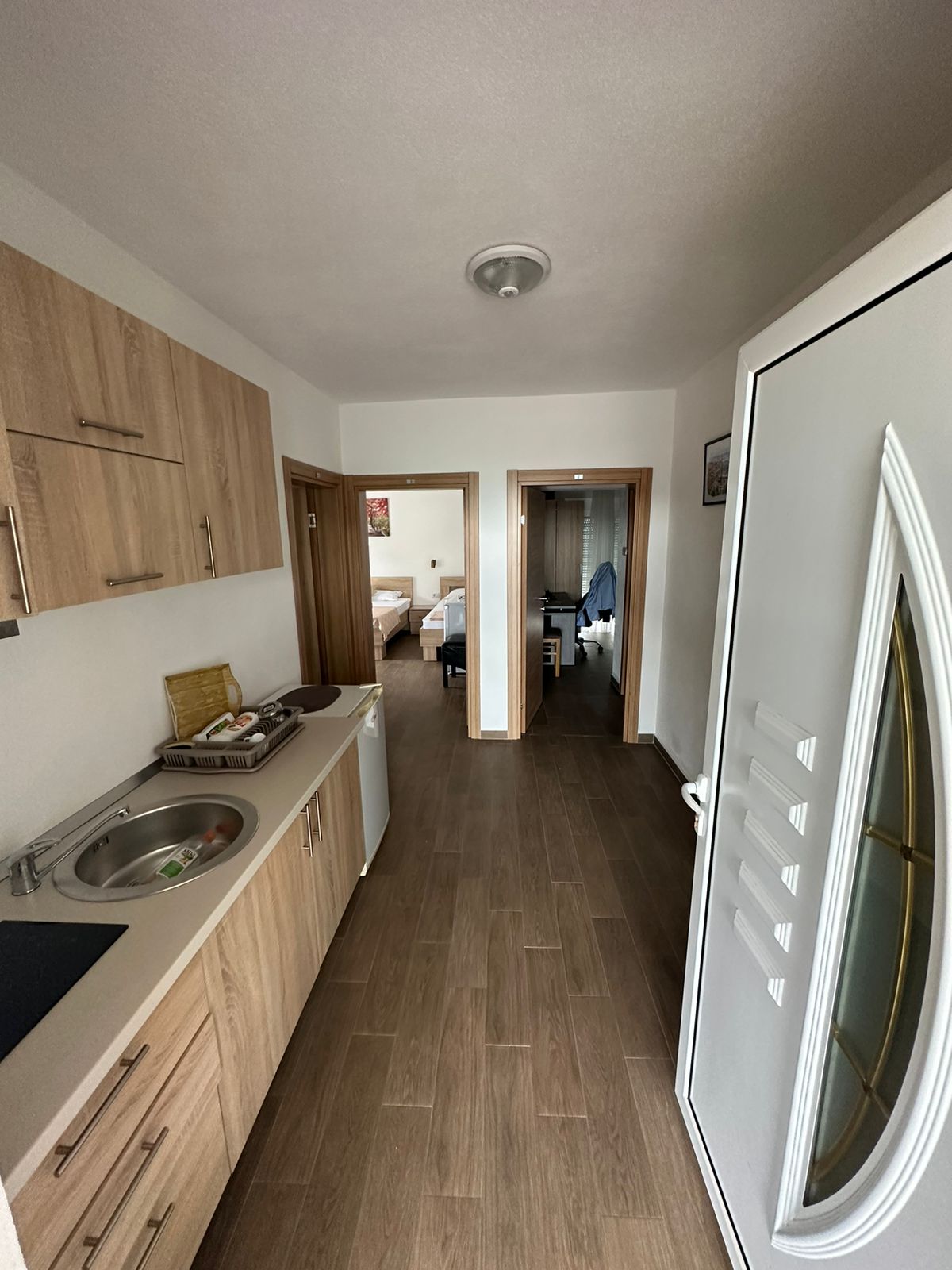 Modern Ulcinj apartment: stylish hallway with eco wood-tile floors, kitchenette, and furnished bedrooms. Exclusive at montenegro-listings.me by ekosphere doo.
