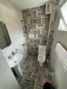 Modern bathroom in Ulcinj property with elegant tiles, shower, and amenities—exclusive listing on montenegro-listings.me by ekosphere doo.